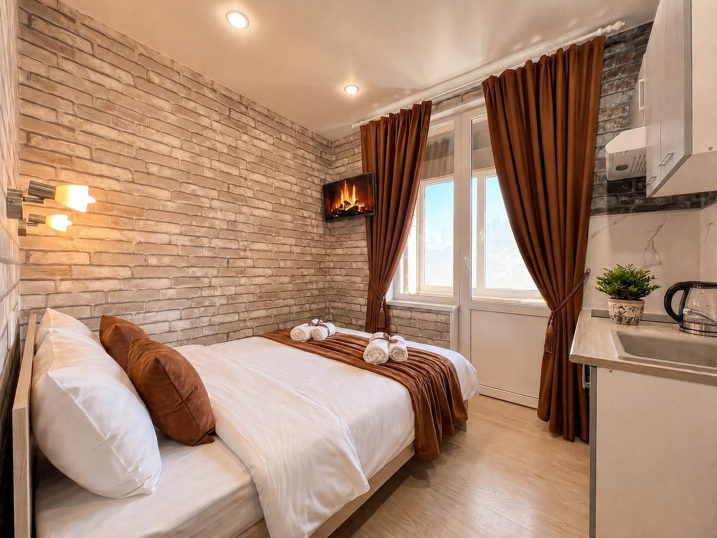 Студия в loft-стиле — двуспальная кровать и кухня